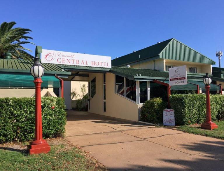 Front entrance of Emerald Central Hotel with green roof and red lamp posts