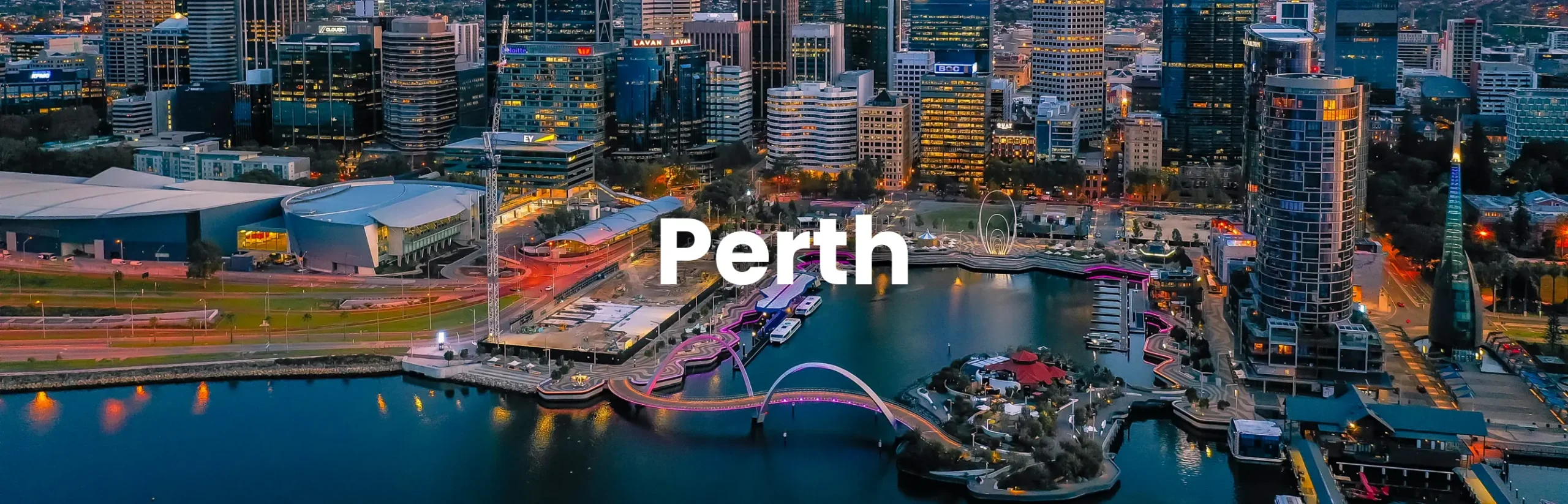 Aerial view of Elizabeth Quay and the Perth city skyline at twilight, showcasing the vibrant setting of the Perth Conference.