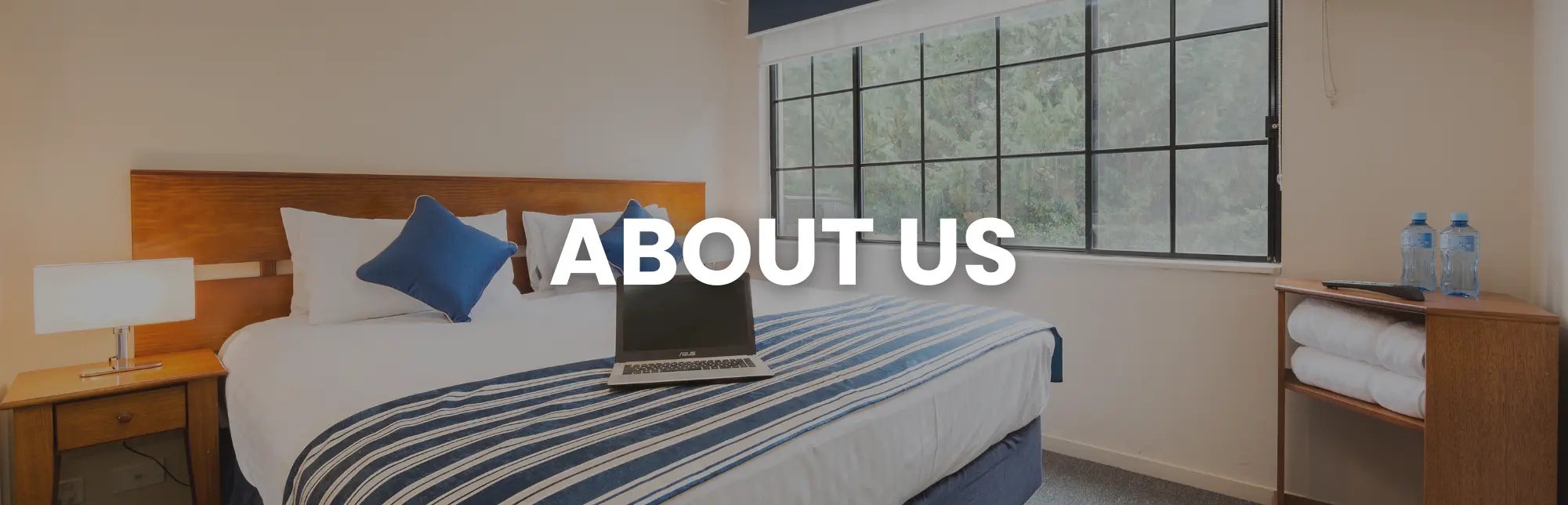 Modern guest room with laptop on bed, representing the professional accommodation and conference services offered by Central Apartment Group — About Us section.